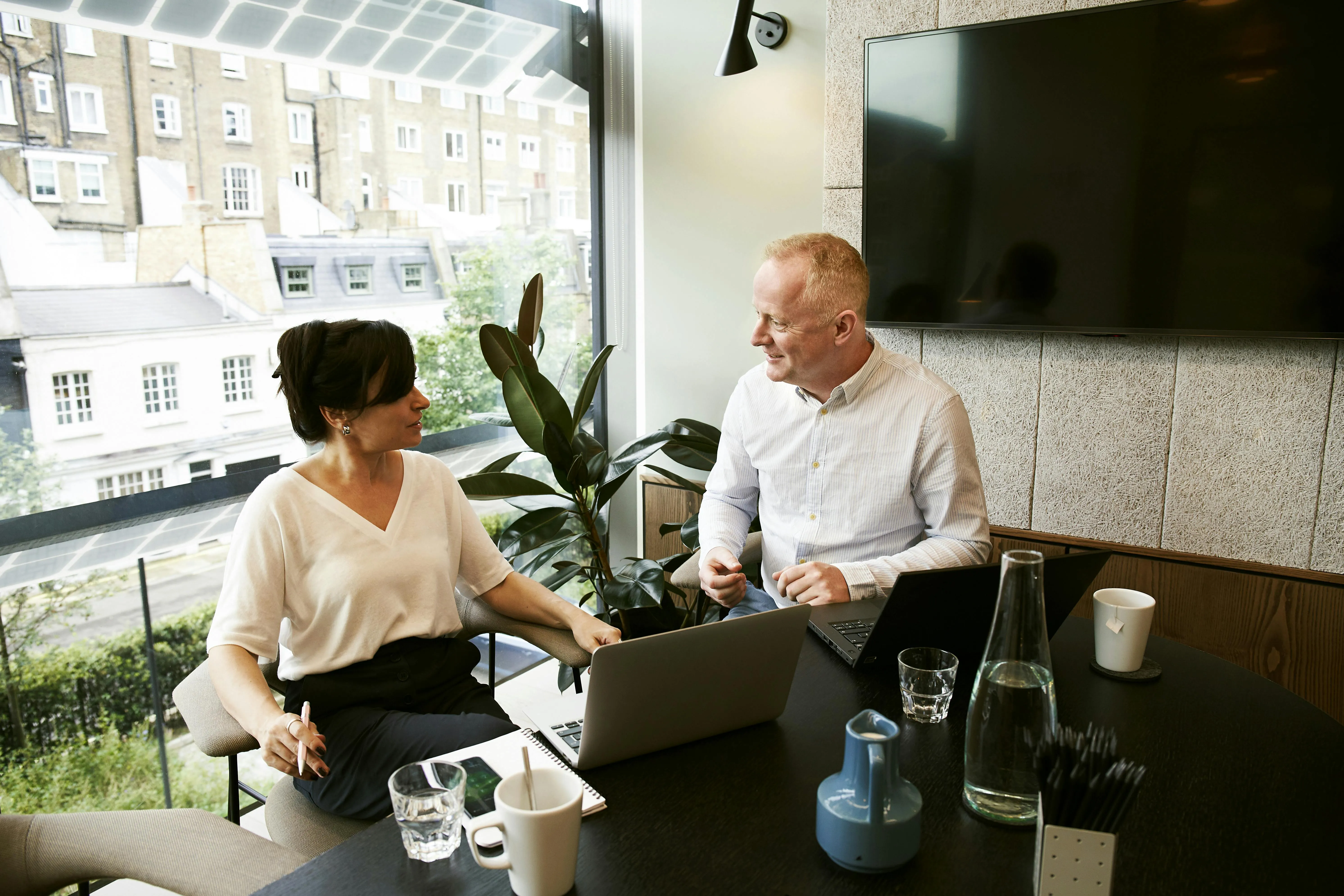 A manager and a colleague in a one-to-one coaching conversation in a meeting room